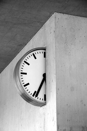 A clock halfway into a concrete wall